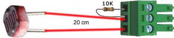 Accessories Kit photoresistor with a dark, round light-sensitive component, red wires and a green screw terminal connector