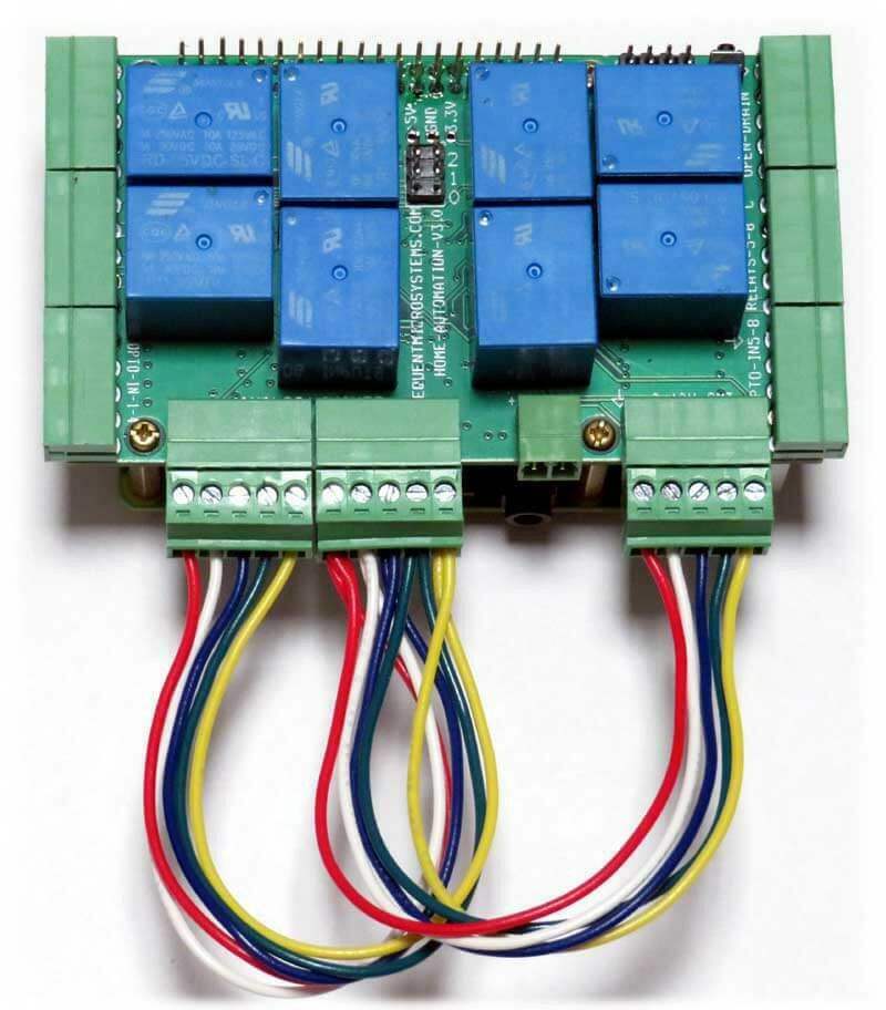 Home Automation circuit board with blue relays, green screw terminals and multicoloured loopback test wires